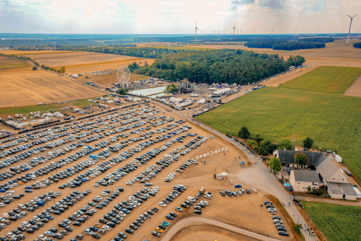 Herzogenaurach Germany 22 July 2022 Aerial view of Open Beatz Festival with a Ferris wheel festival grounds and parking area surrounded by fields and wind turbines. Herzogenaurach Germany 22 July 2022 Aerial view of Open Beatz Festival with a Ferris wheel festival grounds and parking area surrounded by fields and wind turbines.