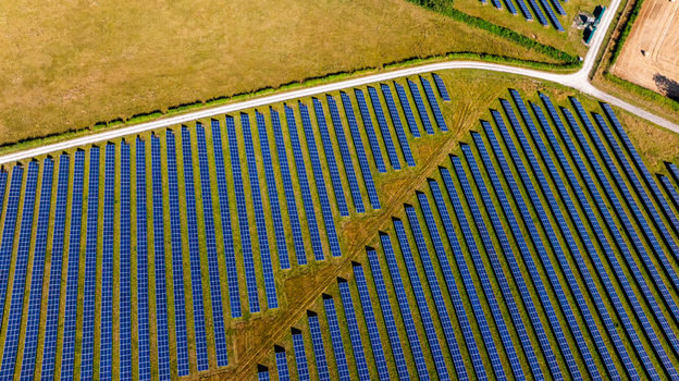 Aerial view of rows of solar panels installed in a green field in the countryside of Dorset England United Kingdom. Aerial view of rows of solar panels installed in a green field in the countryside of Dorset England United Kingdom.