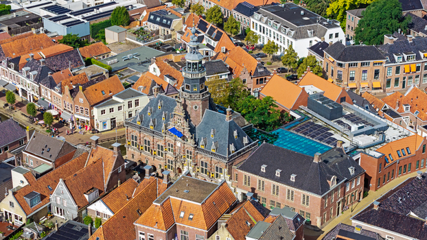 Aerial view of the historic City Hall in Bolsward featuring its ornate tower and surrounding traditional brick buildings with orange tiled roofs Bolsward Friesland Netherlands. Aerial view of the historic City Hall in Bolsward featuring its ornate tower and surrounding traditional brick buildings with orange tiled roofs Bolsward Friesland Netherlands.