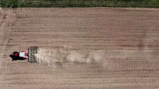 Aerial view of tractor tilling field France.