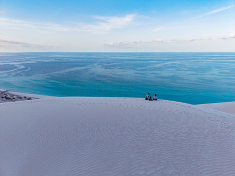 Aerial view of pristine white sand dunes meet the turquoise sea under a soft sky Erissel Socotra Yemen. Aerial view of pristine white sand dunes meet the turquoise sea under a soft sky Erissel Socotra Yemen.