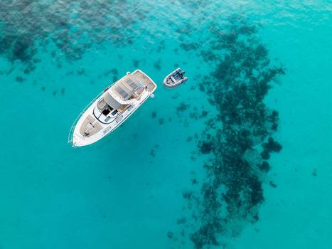 Aerial view of a yacht and dinghy floating on the turquoise waters of the Blue Lagoon Comino Malta. Aerial view of a yacht and dinghy floating on the turquoise waters of the Blue Lagoon Comino Malta.