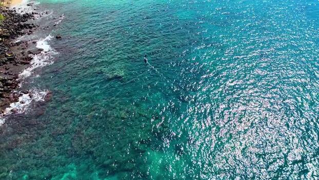 Aerial view of a person hydrofoiling in clear water United States. Aerial view of a person hydrofoiling in clear water United States.