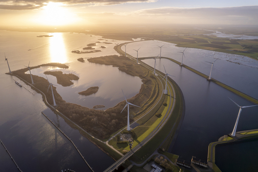 Aerial view of wind turbines along the water channels and coastline in the Netherlands. Aerial view of wind turbines along the water channels and coastline in the Netherlands.
