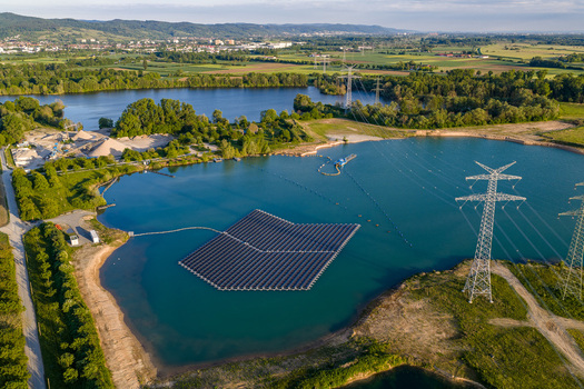 Aerial view of floating on a blue lake surrounded by green fields and high voltage power lines in Bensheim Hessen Germany. Aerial view of floating on a blue lake surrounded by green fields and high voltage power lines in Bensheim Hessen Germany.