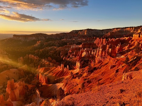 View of Bryce Canyon National Park with red rock hoodoos dramatic geological formations and golden sunset light Utah United States.