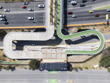 Aerial view of the pedestrian and bicycle bridge at Fundidora Park and Paseo de la Mujer with a green path crossing over a busy highway in Monterrey Nuevo Leon Mexico. Aerial view of the pedestrian and bicycle bridge at Fundidora Park and Paseo de la Mujer with a green path crossing over a busy highway in Monterrey Nuevo Leon Mexico.