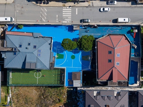 Aerial view of a vibrant blue sports court featuring a basketball hoop and a small soccer field nestled between residential buildings Istanbul Istanbul Turkiye. Aerial view of a vibrant blue sports court featuring a basketball hoop and a small soccer field nestled between residential buildings Istanbul Istanbul Turkiye.