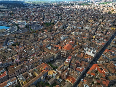 Aerial view of the historic center featuring the Teatro Massimo Bellini and Piazza Vincenzo Bellini surrounded by dense terracotta rooftops Catania Sicily Italy. Aerial view of the historic center featuring the Teatro Massimo Bellini and Piazza Vincenzo Bellini surrounded by dense terracotta rooftops Catania Sicily Italy.