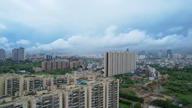 Aerial view of Gurugram skyscrapers and green fields India.