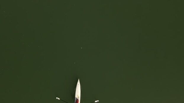 Aerial view of a person rowing a boat on a river France. Aerial view of a person rowing a boat on a river France.