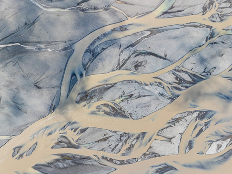 Aerial view of a braided river with intricate glacial water channels and grey sediment banks in Iceland. Aerial view of a braided river with intricate glacial water channels and grey sediment banks in Iceland.