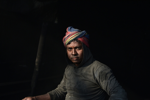 Kushtia District Khulna Division Bangladesh 28 November 2020 View of a man wearing a colorful turban and a dark hoodie captured in dramatic lighting against a dark background. Kushtia District Khulna Division Bangladesh 28 November 2020 View of a man wearing a colorful turban and a dark hoodie captured in dramatic lighting against a dark background.