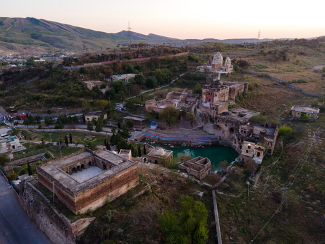 Aerial view of Katas Raj Temple Complex featuring ancient Hindu temples a sacred pond and historic stone structures set against a hilly landscape in Katas Punjab Pakistan. Aerial view of Katas Raj Temple Complex featuring ancient Hindu temples a sacred pond and historic stone structures set against a hilly landscape in Katas Punjab Pakistan.