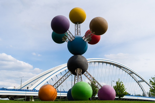Bratislava Slovakia 09 May 2026 View of the colorful molecular sculpture with the modern Apollo Bridge in the background under a blue sky.
