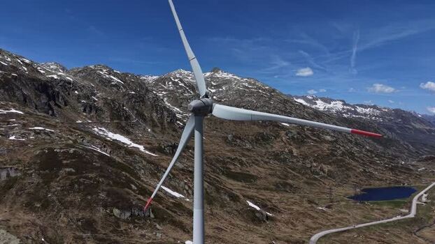 Aerial view of a wind turbine in the mountains of Switzerland. Aerial view of a wind turbine in the mountains of Switzerland.