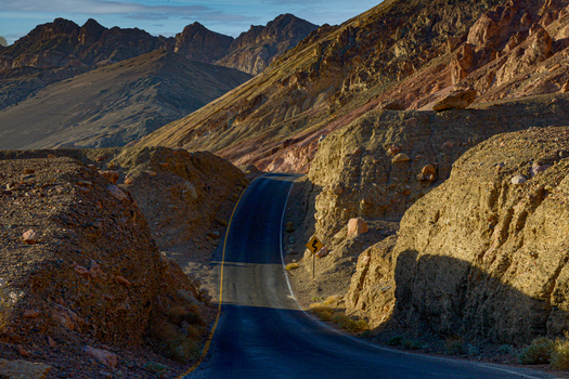View of a winding road through the rugged rocky desert landscape of Death Valley National Park s backcountry in Death Valley California United States.