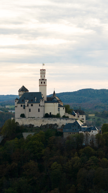Aerial view of Marksburg castle perched on a hilltop surrounded by lush forests in Braubach Rhineland Palatinate Germany. Aerial view of Marksburg castle perched on a hilltop surrounded by lush forests in Braubach Rhineland Palatinate Germany.