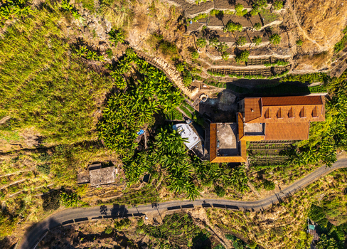 Aerial view of Trilha do Vale do Paul showing terraced fields banana plantations a house with a tiled roof and a winding road Faja de Cima Paul Cabo Verde.
