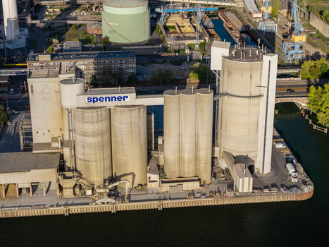 Berlin Germany 21 September 2026 Aerial view of the Spenner cement plant with tall concrete silos industrial infrastructure and loading docks along the riverbank. Berlin Germany 21 September 2026 Aerial view of the Spenner cement plant with tall concrete silos industrial infrastructure and loading docks along the riverbank.