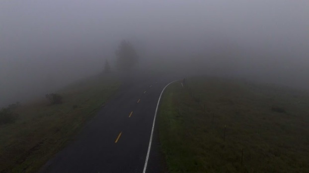 Aerial view of a winding road in thick fog United States. Aerial view of a winding road in thick fog United States.
