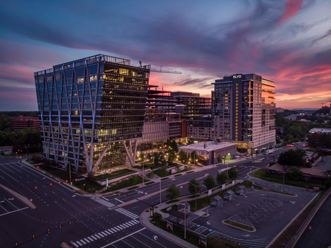 Reston Virginia United States 27 May 2020 Aerial view of modern office buildings and residential towers at sunset with vibrant clouds and street lights. Reston Virginia United States 27 May 2020 Aerial view of modern office buildings and residential towers at sunset with vibrant clouds and street lights.