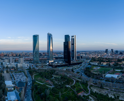 Aerial view of the Cuatro Torres Business Area featuring modern skyscrapers rising above the urban landscape and surrounding parkland in Madrid Comunidad de Madrid Spain. Aerial view of the Cuatro Torres Business Area featuring modern skyscrapers rising above the urban landscape and surrounding parkland in Madrid Comunidad de Madrid Spain.