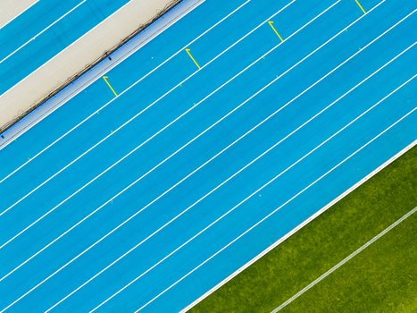 Aerial view of athletic stadium with blue running track lanes and green grass field in Chorzow Wojewodztwo slaskie Poland.