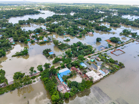 Aerial view of flooded houses and trees surrounded by murky floodwaters in Banshkhali Upazila Chittagong Division Bangladesh. Aerial view of flooded houses and trees surrounded by murky floodwaters in Banshkhali Upazila Chittagong Division Bangladesh.