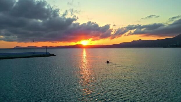 Aerial view of a person kayaking at sunset in Crete Greece.