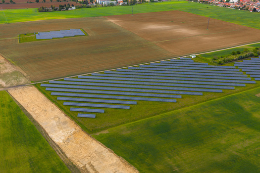 Aerial view of a large solar farm with rows of photovoltaic panels installed in a green field surrounded by agricultural land and rural landscape in Breclav South Moravian Region Czechia.