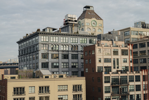 View of the Brooklyn Bridge and surrounding historic industrial buildings with large windows and a clock tower in New York New York United States.