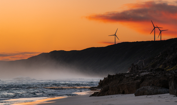 View of wind turbines on the coastal cliffs at Sandpatch beach during a vibrant sunset with mist rolling over the waves Sandpatch Western Australia Australia. View of wind turbines on the coastal cliffs at Sandpatch beach during a vibrant sunset with mist rolling over the waves Sandpatch Western Australia Australia.