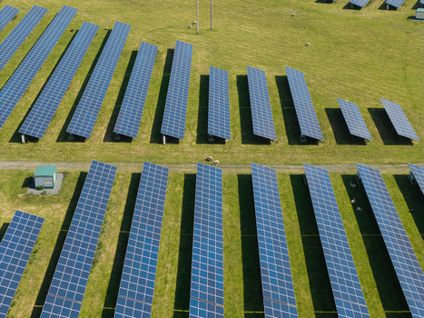 Aerial view of Lisburn Solar Farm featuring rows of photovoltaic panels installed on green grassy fields in Lisburn Northern Ireland United Kingdom. Aerial view of Lisburn Solar Farm featuring rows of photovoltaic panels installed on green grassy fields in Lisburn Northern Ireland United Kingdom.