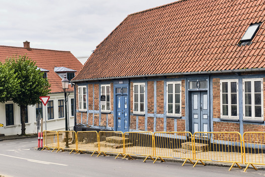 Viborg Denmark 07 August 2026 View of traditional timber framed houses in the historic old town featuring red tiled roofs blue wooden frames and yellow safety barriers. Viborg Denmark 07 August 2026 View of traditional timber framed houses in the historic old town featuring red tiled roofs blue wooden frames and yellow safety barriers.
