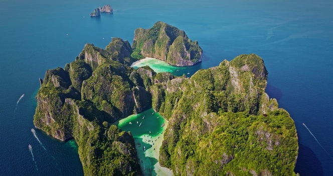 Aerial view of the lush limestone cliffs and turquoise waters of Maya Bay in the Phi Phi Islands Thailand. Aerial view of the lush limestone cliffs and turquoise waters of Maya Bay in the Phi Phi Islands Thailand.