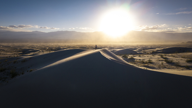 Aerial view of Dunas de Taton with a person standing on a sand dune under the golden sun in Tinogasta Department Catamarca Province Argentina. Aerial view of Dunas de Taton with a person standing on a sand dune under the golden sun in Tinogasta Department Catamarca Province Argentina.