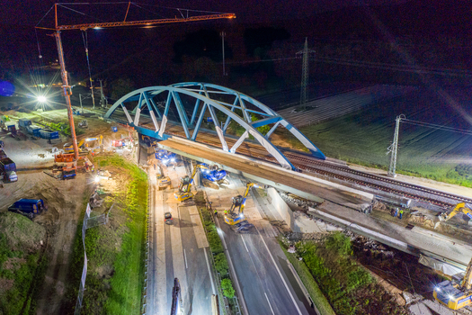 Forchheim Germany 18 May 2024 Aerial view of the A73 highway bridge construction site at night with a large crane excavators and bright floodlights. Forchheim Germany 18 May 2024 Aerial view of the A73 highway bridge construction site at night with a large crane excavators and bright floodlights.