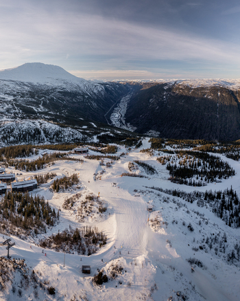 Aerial view of Gaustablikk Fjellresort surrounded by snow covered ski slopes pine forests and mountain peaks under a clear sky in Rjukan Telemark Norway. Aerial view of Gaustablikk Fjellresort surrounded by snow covered ski slopes pine forests and mountain peaks under a clear sky in Rjukan Telemark Norway.