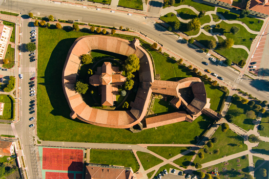 Aerial view of the historic Prejmer Fortified Church with its circular defensive walls red tiled roofs and surrounding green lawns in Prejmer Brasov Romania. Aerial view of the historic Prejmer Fortified Church with its circular defensive walls red tiled roofs and surrounding green lawns in Prejmer Brasov Romania.