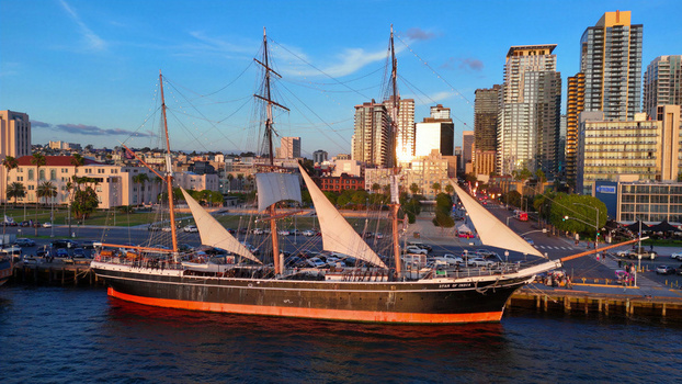 San Diego United States 01 April 2026 Aerial view of the historic Star of India tall ship docked at the North Embarcadero with the city skyline and golden hour light.