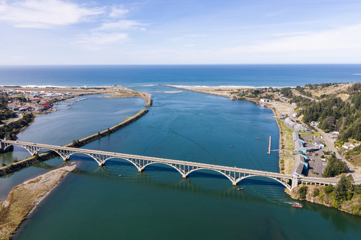 Aerial view of the Isaac Lee Patterson Bridge spanning the Rogue River near the Pacific Ocean coastline in Gold Beach Oregon United States. Aerial view of the Isaac Lee Patterson Bridge spanning the Rogue River near the Pacific Ocean coastline in Gold Beach Oregon United States.