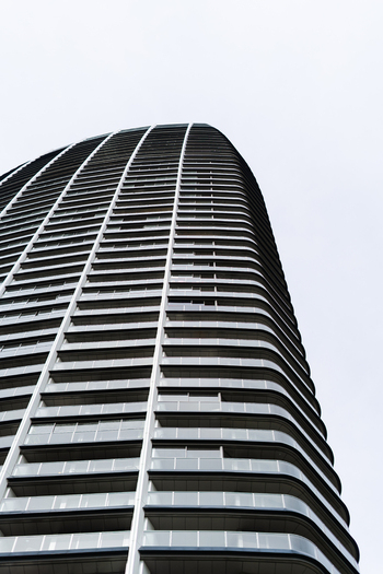 View of the modern curved architecture of a Sky Park residential tower with glass balconies against an overcast sky in Bratislava Bratislava Region Slovakia. View of the modern curved architecture of a Sky Park residential tower with glass balconies against an overcast sky in Bratislava Bratislava Region Slovakia.