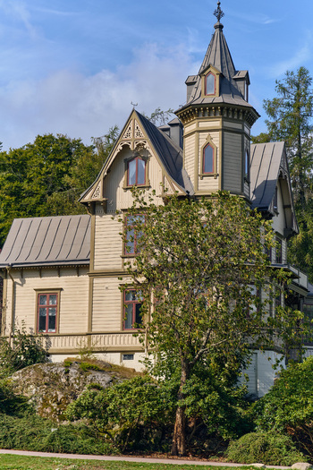Ronneby Blekinge County Sweden 12 September 2025 View of a historic 19th century wooden villa in Brunssparken featuring ornate architectural details and a prominent turret. Ronneby Blekinge County Sweden 12 September 2025 View of a historic 19th century wooden villa in Brunssparken featuring ornate architectural details and a prominent turret.