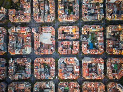 Aerial view of the Eixample district featuring its iconic grid layout octagonal city blocks and terracotta rooftops in Barcelona Catalonia Spain.