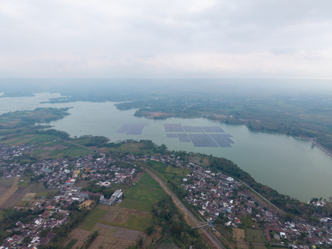 Aerial view of Sutami Dam in Karangkates with floating solar panels on the reservoir surrounded by residential areas and lush green landscape in Kecamatan Sumberpucung Jawa Timur Indonesia. Aerial view of Sutami Dam in Karangkates with floating solar panels on the reservoir surrounded by residential areas and lush green landscape in Kecamatan Sumberpucung Jawa Timur Indonesia.