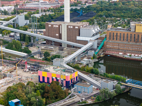 Aerial view of Heizkraftwerk Reuter West power plant with its tall chimney coal storage conveyor systems and colorful industrial buildings in Berlin Berlin Germany.