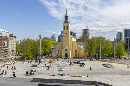 Tallinn Estonia 16 May 2026 View of St. John s Church in Freedom Square with people walking across the paved plaza under a blue sky.
