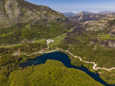 Aerial view of the Blue Eye spring a natural water feature with deep blue water surrounded by lush green forests and rugged mountains in Finiq Vlore County Albania. Aerial view of the Blue Eye spring a natural water feature with deep blue water surrounded by lush green forests and rugged mountains in Finiq Vlore County Albania.