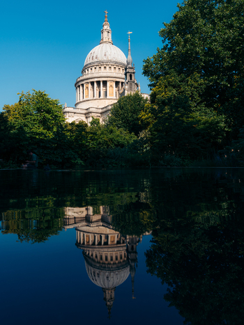 London United Kingdom 19 June 2025 View of St Paul s Cathedral reflected in the tranquil dark waters framed by vibrant green trees against a clear azure sky. London United Kingdom 19 June 2025 View of St Paul s Cathedral reflected in the tranquil dark waters framed by vibrant green trees against a clear azure sky.
